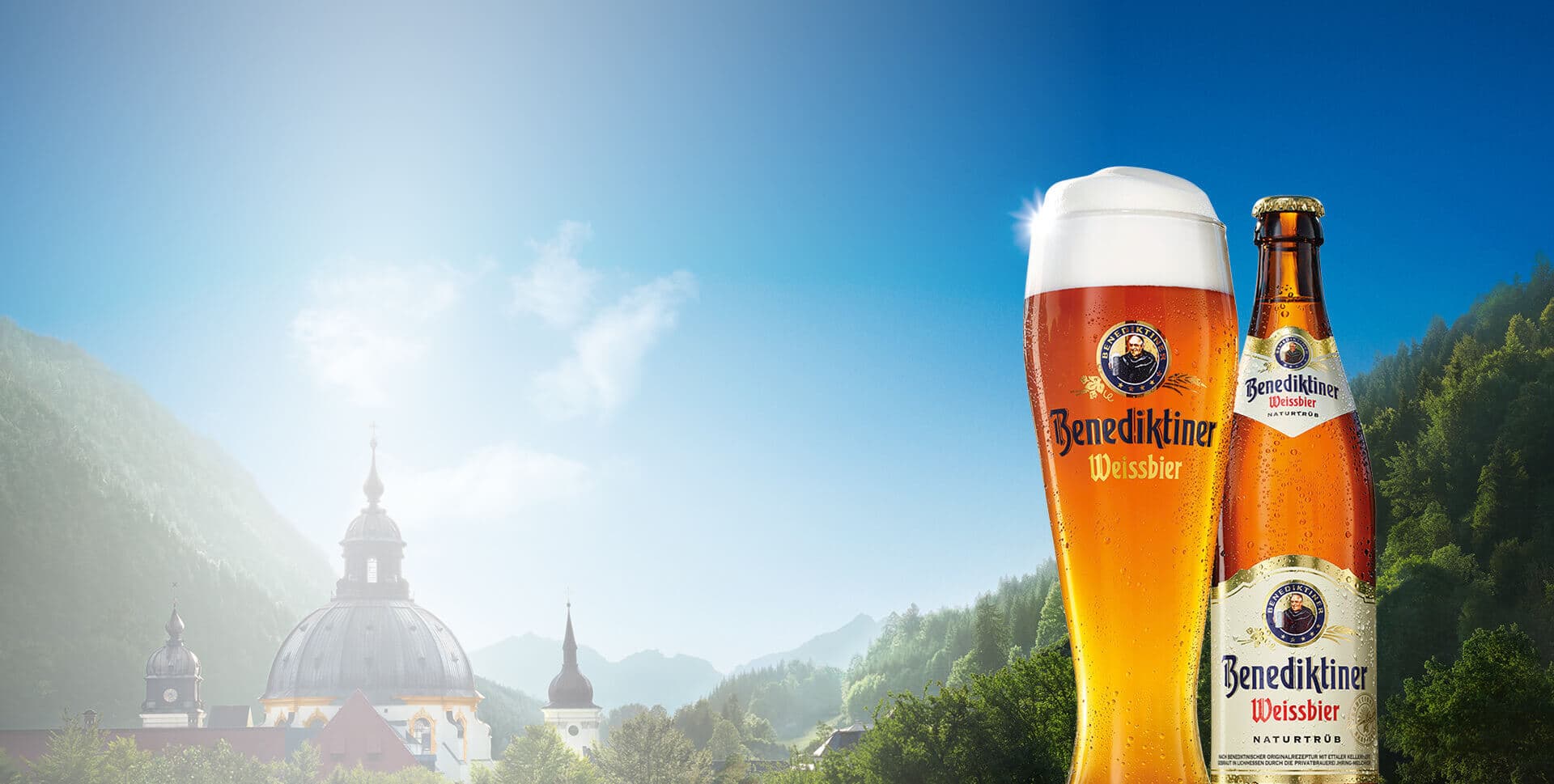 Benediktiner Weissbier Naturtrüb bên ly bia, phía sau là Tu viện Ettal và dãy Alps